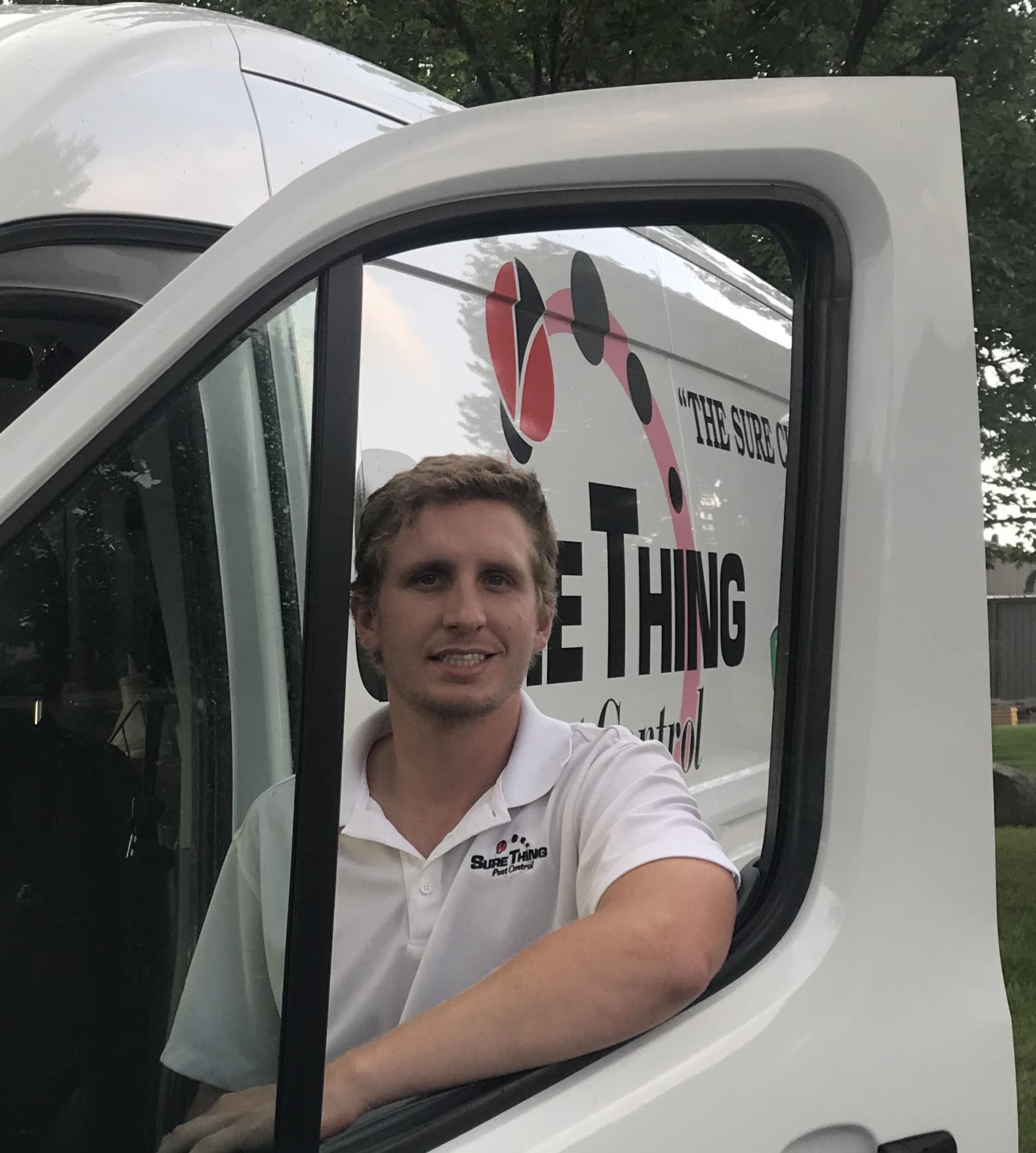 Sure Thing Pest Control technician smiling in branded service van