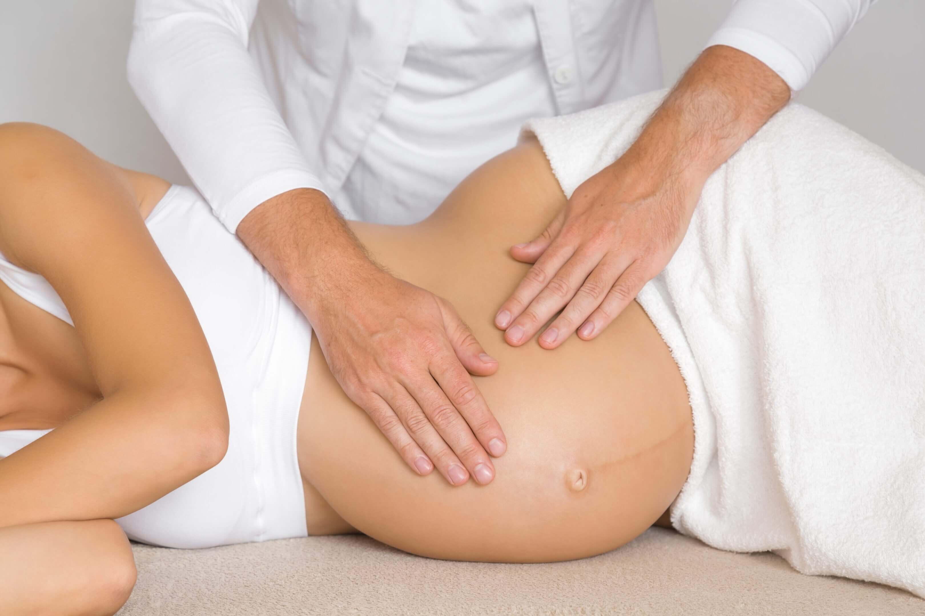 Massage therapist performing prenatal massage on a pregnant client.