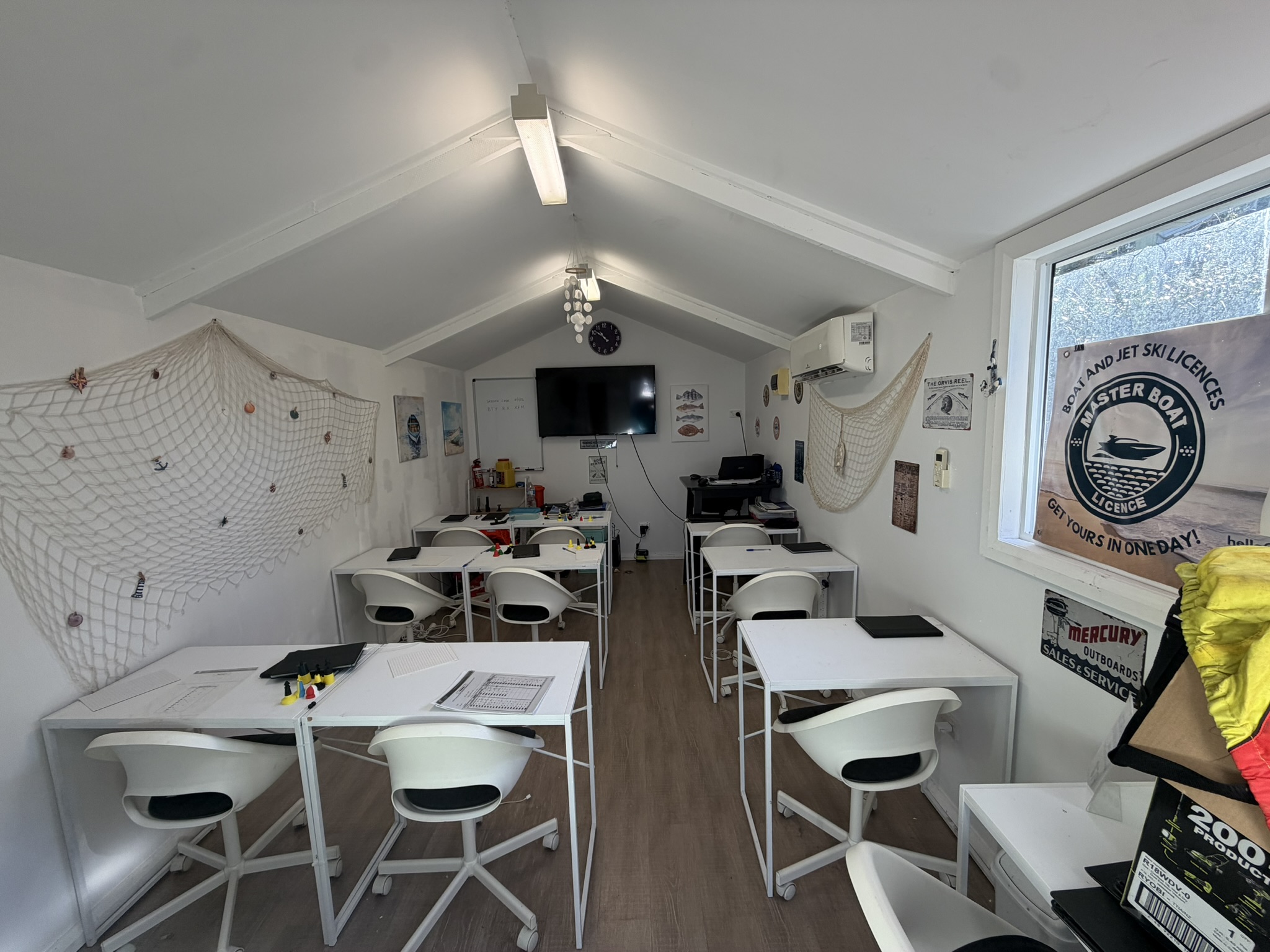 Interior view of the Master Boat Licence training classroom with white desks and chairs.